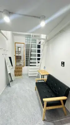 a room with a couch and a table and stairs at Megun 10 Duplex in Bangkok