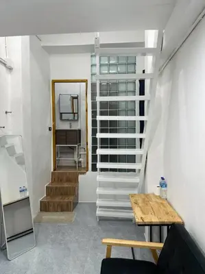 a room with stairs and a table and a mirror at Megun 10 Duplex in Bangkok