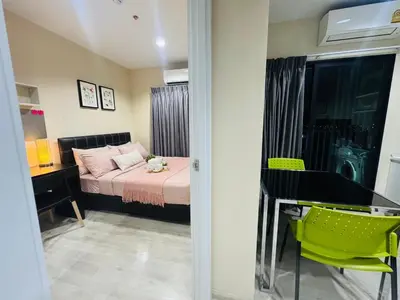 a bedroom with a bed and a table with a green chair at 1 Bedroom Next to IKEA,Central Westgate46 in Ban Bang Krabu