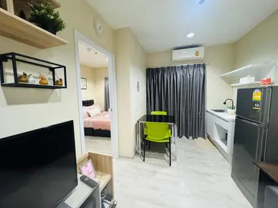 a small room with a kitchen with a table and a refrigerator at 1 Bedroom Next to IKEA,Central Westgate46 in Ban Bang Krabu