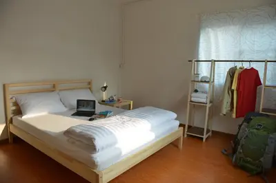 a bedroom with a bed with a laptop on it at PanPan Hostel in Bangkok