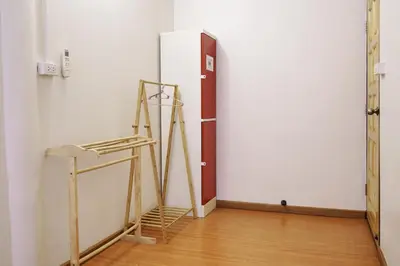 a room with a refrigerator and a wooden floor at PanPan Hostel in Bangkok