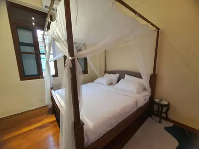 a bedroom with a canopy bed with white sheets at The Courtesan at Yaowarat, townhome 80 Sqm in Samphanthawong