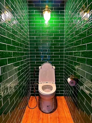 a green tiled bathroom with a toilet with a light at The Courtesan at Yaowarat, townhome 80 Sqm in Samphanthawong