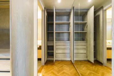 a walk in closet with wooden floors and glass doors at Designer Pool Villa in Ekkamai in Bangkok