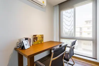 a desk in a room with a window and chairs at Designer Pool Villa in Ekkamai in Bangkok