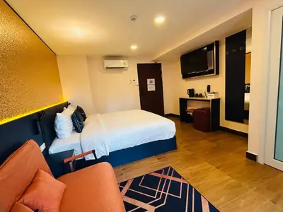 a hotel room with a bed and a tv at Emiri Hotel - Nana Bangkok in Bangkok