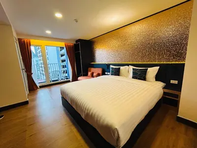 a hotel room with a large bed and a chair at Emiri Hotel - Nana Bangkok in Bangkok
