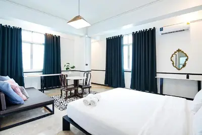 a bedroom with a white bed and a table and chairs at xx The Character China Town MRT วัดมังกร in Bangkok