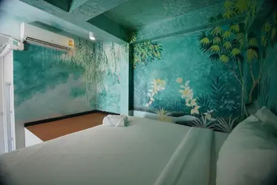 a bedroom with a bed with a painting on the wall at xx The Character China Town MRT วัดมังกร in Bangkok