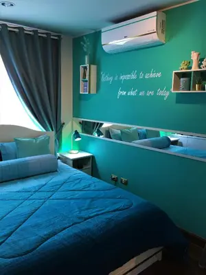 a bedroom with a bed and a blue wall at White Turquoise -2 Bedrooms Apartment- in Bangkok