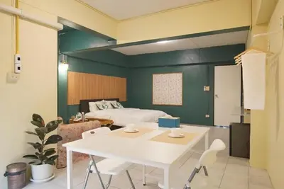 a room with a bed and a table and chairs at z GO INN The Grand Palace Bangkok-Mrt Samyot Station in Bangkok
