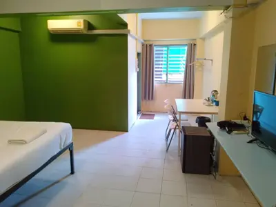 a room with a bed and a green wall at z GO INN The Grand Palace Bangkok-Mrt Samyot Station in Bangkok