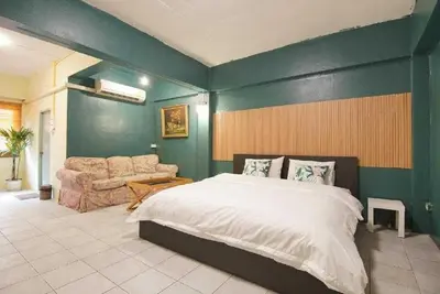 a bedroom with a large bed and a couch at z GO INN The Grand Palace Bangkok-Mrt Samyot Station in Bangkok