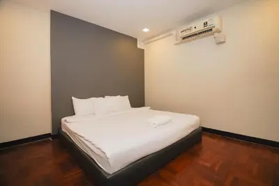 a bedroom with a bed with white sheets at XX GO INN Silom Road -BTS Saint Louis in Bangkok