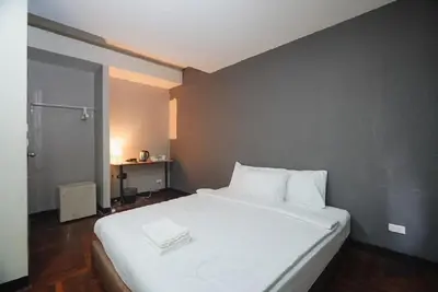 a bedroom with a large white bed with white pillows at XX GO INN Silom Road -BTS Saint Louis in Bangkok