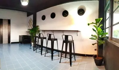 a group of stools in a room with a wall at ONEWAY Guest House BKK in Bangkok