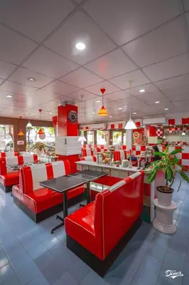 a restaurant with red and white chairs and tables at ONEWAY Guest House BKK in Bangkok