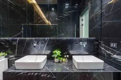 a bathroom with two sinks and a black wall at The Oasis Tranquil Escape in Bangkok