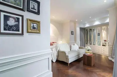 a living room with a white couch and pictures on the wall at The Oasis Tranquil Escape in Bangkok