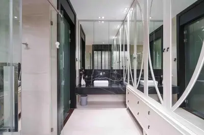 a bathroom with a black vanity and a large mirror at The Oasis Tranquil Escape in Bangkok