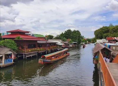 a boat is docked on a river next to buildings at Bangkok Siam in Bangkok