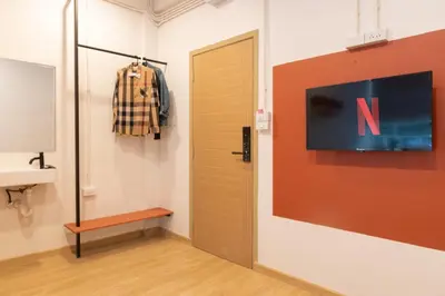 a room with a door and a tv on a wall at Samyan Story Boutique Hotel in Bangkok