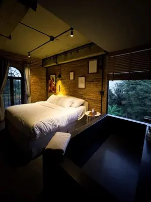 a bedroom with a large bed and a window at Cataleya Estate Boutique Bed & Breakfast in Bangkok