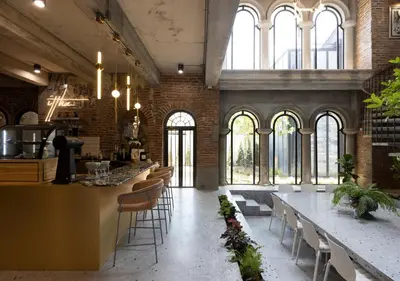 a large room with tables and chairs and windows at Cataleya Estate Boutique Bed & Breakfast in Bangkok
