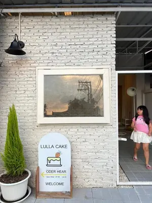a woman standing in front of a building with a painting at Vanilla house in Nonthaburi