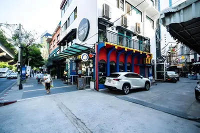 a white car parked on the side of a city street at Elite Hotel Asok Sukhumvit 20 in Bangkok