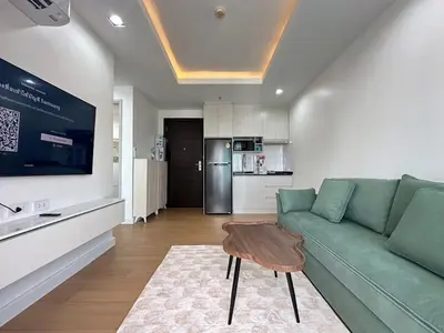 a living room with a green couch and a table at 1BHK Apt High floor in Thonglor WiFi-Pool-Fitness in Bangkok