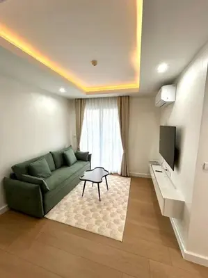 a living room with a green couch and a tv at 1BHK Apt High floor in Thonglor WiFi-Pool-Fitness in Bangkok