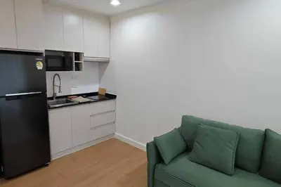 a living room with a green couch in a kitchen at 1BHK Apt High floor in Thonglor WiFi-Pool-Fitness in Bangkok