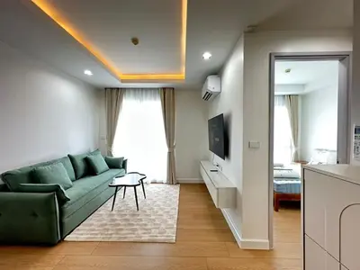 a living room with a green couch and a television at 1BHK Apt High floor in Thonglor WiFi-Pool-Fitness in Bangkok
