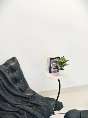 a chair and a table with a book and a plant at Fivehouse Silom1 - City heart - Silom -BTS MRT 2min - lumpini park - bnh in Bangkok