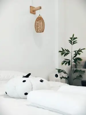 a white teddy bear sitting on top of a bed at Fivehouse Silom1 - City heart - Silom -BTS MRT 2min - lumpini park - bnh in Bangkok