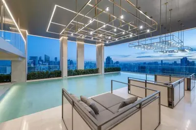 a swimming pool in a building with a view of the city at Pet Friendly Modern Nest Asoke in Bangkok