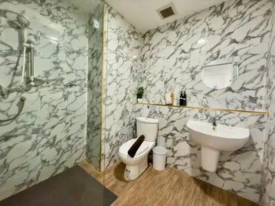 a bathroom with a toilet and a sink at Breezewood Bangkok Hotel in Bang Su