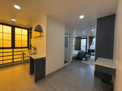 a room with a kitchen and a living room at Breezewood Bangkok Hotel in Bang Su