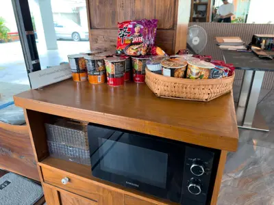 a table with food and baskets on top of a microwave at Breezewood Bangkok Hotel in Bang Su