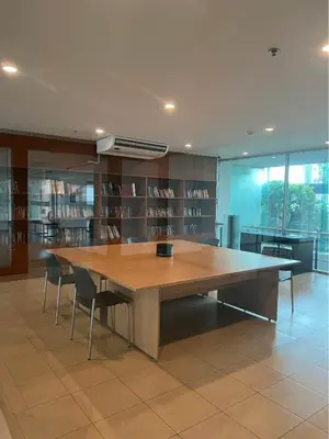 a large wooden table in a library with chairs at Riverside room with best view in heart of BKK in Godown