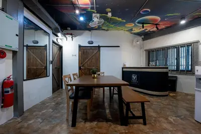 a dining room with a table and chairs in a room at Vibes Hostel Bangkok in Bangkok
