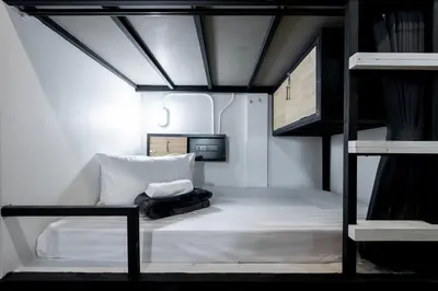 a small room with a bunk bed in a building at Vibes Hostel Bangkok in Bangkok