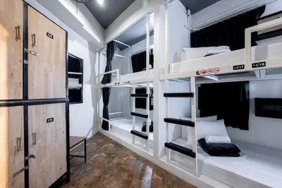 a room with four bunk beds in it with a door at Vibes Hostel Bangkok in Bangkok