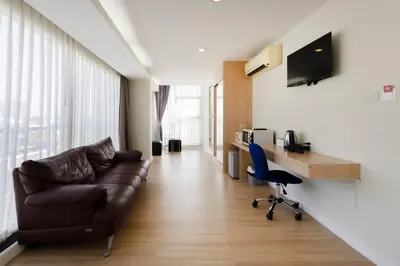 a living room with a couch and a desk at GP House Express Sukhumvit 81 in Bangkok