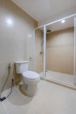 a white bathroom with a toilet and a shower at GP House Express Sukhumvit 81 in Bangkok