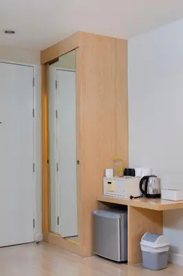 a kitchen with a door and a counter with a microwave at GP House Express Sukhumvit 81 in Bangkok