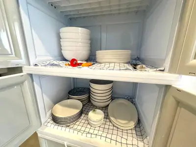 a refrigerator filled with plates and bowls and dishes at The White Den Chatuchak in Bang O