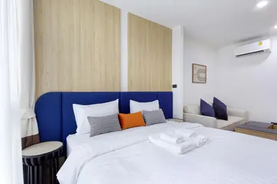 a bedroom with a blue and white bed with pillows at Aquila Hotel Bangkok in Bangkok